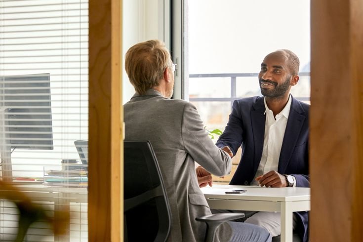 Advisor and member shaking hands in an office