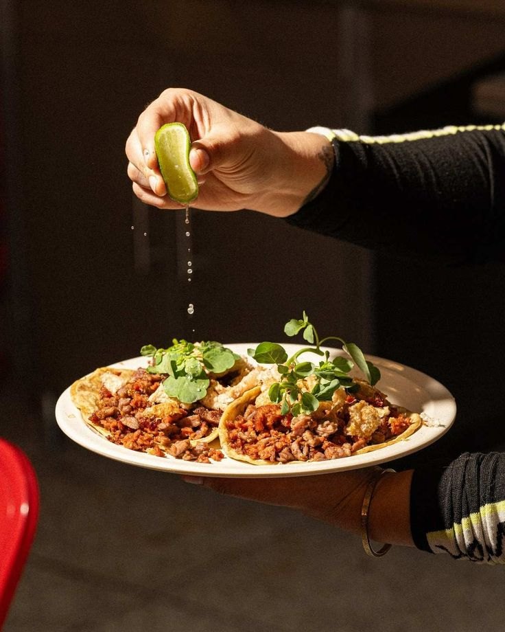 Lime squeezed over a plate of tacos